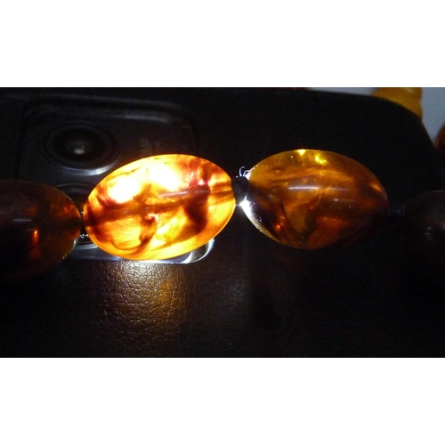 957 - A collection of amber and amber style jewellery including a silver mounted ring