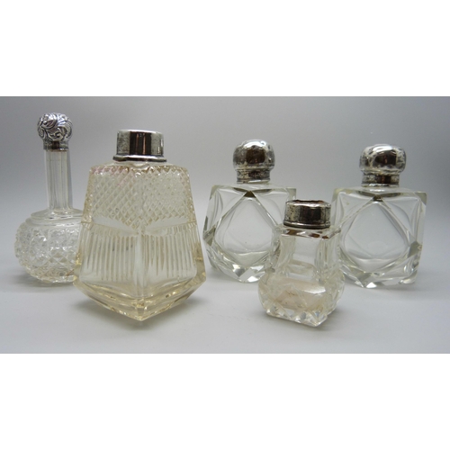 958 - A collection of silver mounted scent bottles - three lacking stoppers, one lid unremovable, one lid ... 