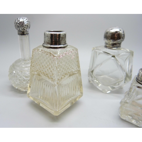 958 - A collection of silver mounted scent bottles - three lacking stoppers, one lid unremovable, one lid ... 