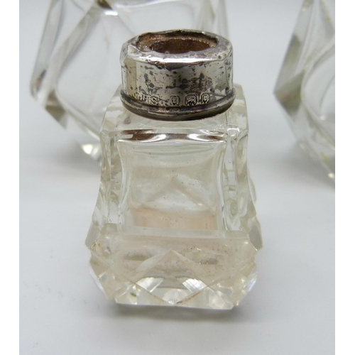 958 - A collection of silver mounted scent bottles - three lacking stoppers, one lid unremovable, one lid ... 