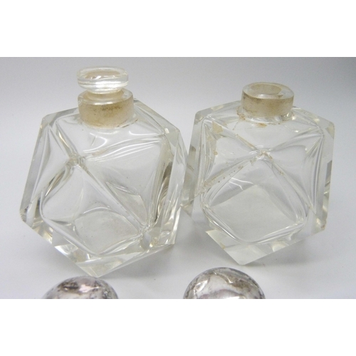 958 - A collection of silver mounted scent bottles - three lacking stoppers, one lid unremovable, one lid ... 