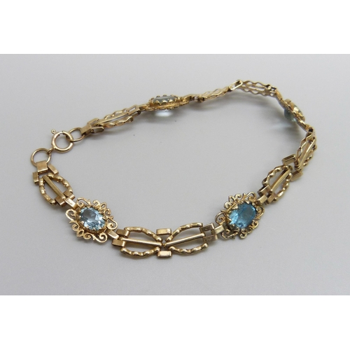 984 - A 9ct gold bracelet set with four topaz stones, one replacement, 5.8g