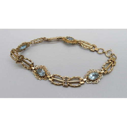 984 - A 9ct gold bracelet set with four topaz stones, one replacement, 5.8g