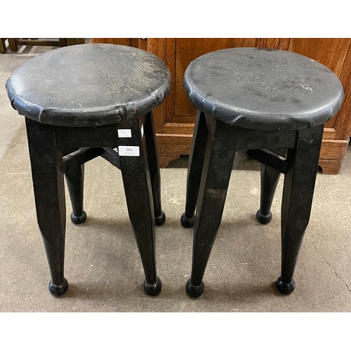 201 - A pair of Arts and Crafts ebonised and leather top stools