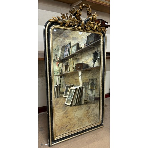 310 - A French Empire ebonised and parcel gilt framed mirror