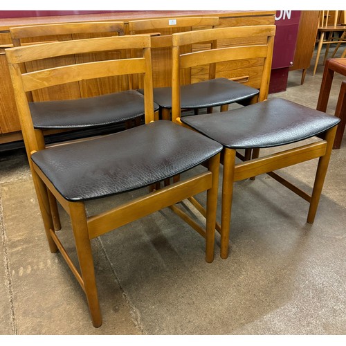 36 - A set of four teak and black vinyl dining chairs