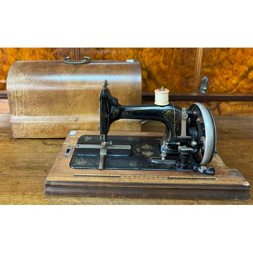 252A - A Victorian cast iron mother of pearl inlaid cased sewing machine