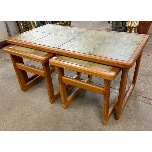 55C - A teak tiled top nest of tables