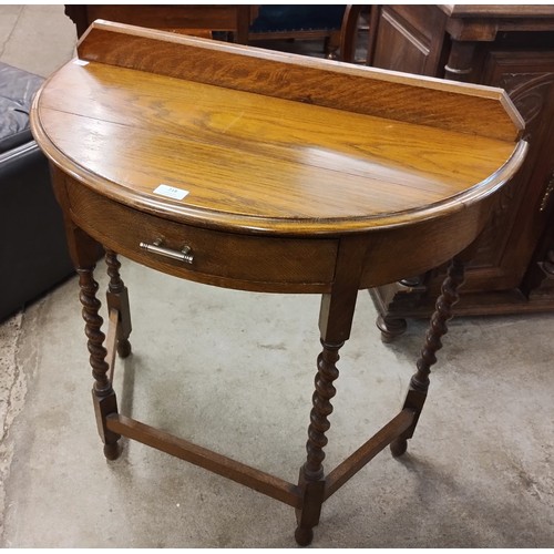 218 - An early 20th Century oak barleytwist single drawer demi lune hall table