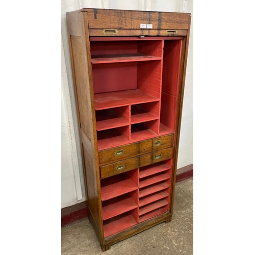 135 - An early 20th century oak tambour front cabinet