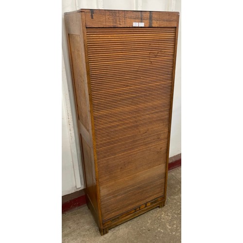 135 - An early 20th century oak tambour front cabinet