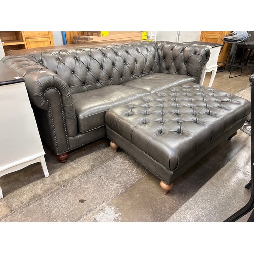 3133 - A dark green leather Chesterfield three seater sofa and footstool