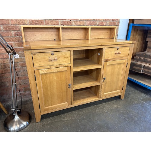 3137 - A solid oak two door two drawer sideboard with storage shelves (slight damage and a splinter on the ... 