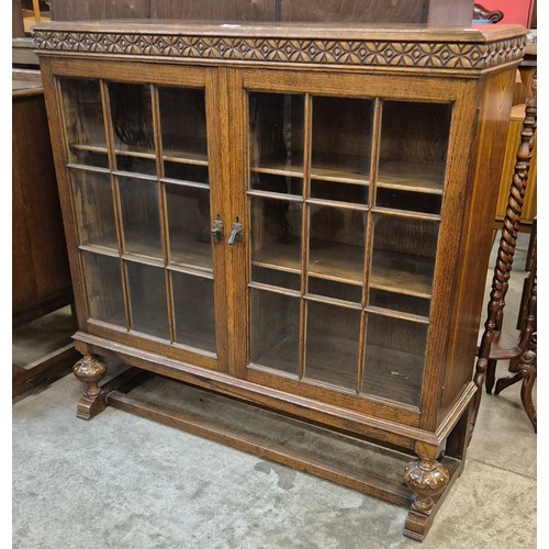 162 - An early 20th Century Waring & Gillow carved oak two door bookcase