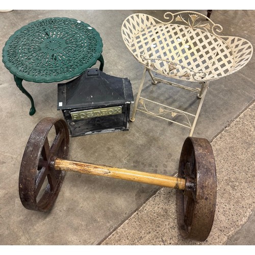 205 - A set of cast iron cartwheels, two metal garden tables and a cast alloy postbox and a display case