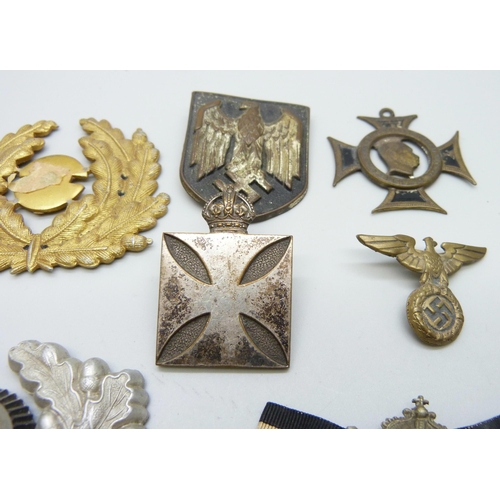 2081 - A collection of badges, etc., including a German WWII pith helmet eagle shield, a German army visor ... 