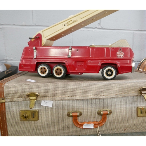 2351 - A large collection of vintage toys in a suitcase including a large 1970s fire engine, 1950s lanterns... 