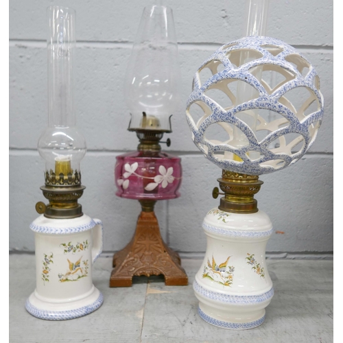 2354 - Three oil lamps including one with a cranberry glass reservoir **PLEASE NOTE THIS LOT IS NOT ELIGIBL... 