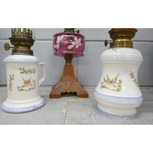 2354 - Three oil lamps including one with a cranberry glass reservoir **PLEASE NOTE THIS LOT IS NOT ELIGIBL... 