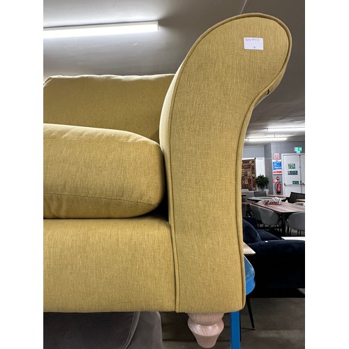 3110 - A bumblebee yellow upholstered two seater sofa on turned oak legs