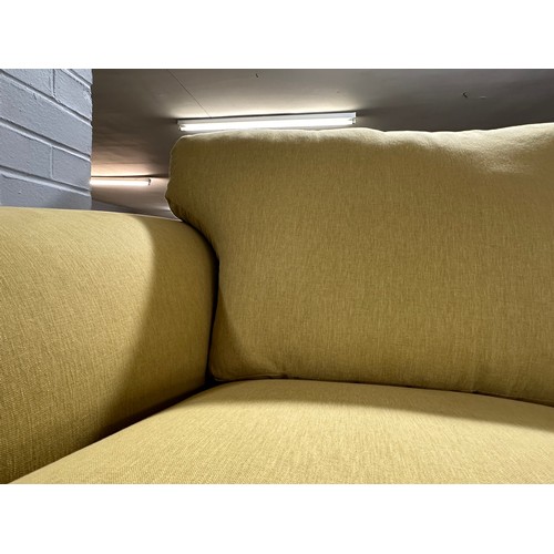 3110 - A bumblebee yellow upholstered two seater sofa on turned oak legs