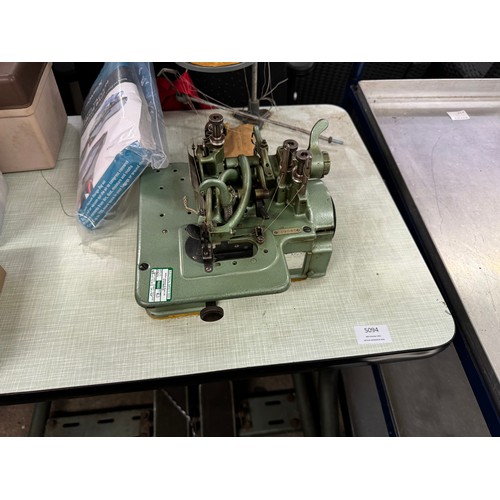 5138 - A Wilcox and Gibbs overlock sewing machine with an assortment of threads and needles, etc.