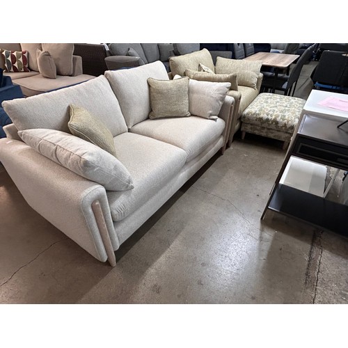 3059 - An ivory two seater sofa, an olive green armchair and footstool on a semi exposed frame