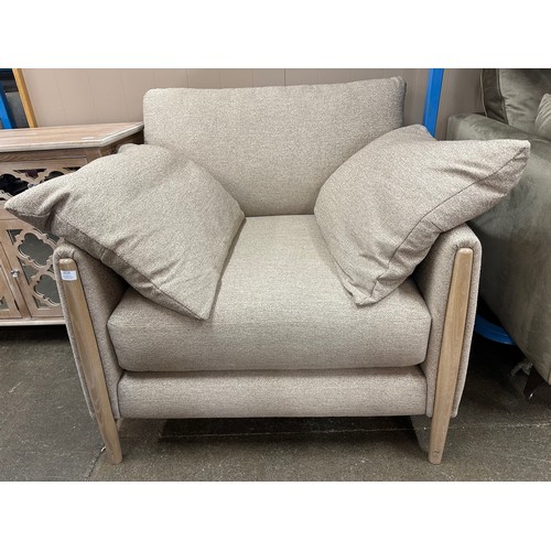 3119 - An oatmeal upholstered armchair on a semi exposed frame