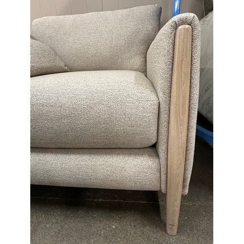 3119 - An oatmeal upholstered armchair on a semi exposed frame