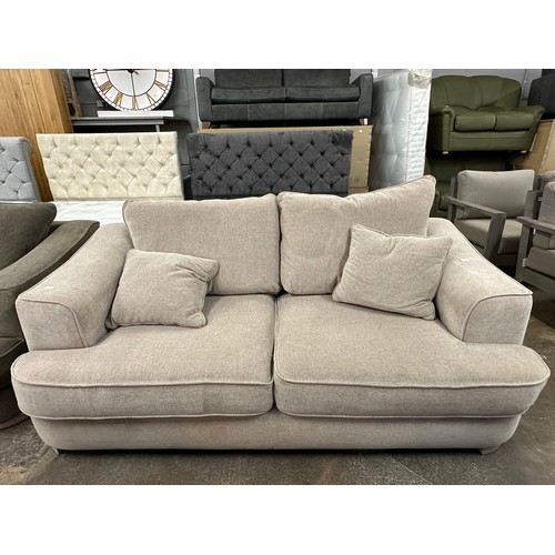 3147 - A beech beige upholstered 2.5 seater sofa on light oak legs, tear to inside of cushion