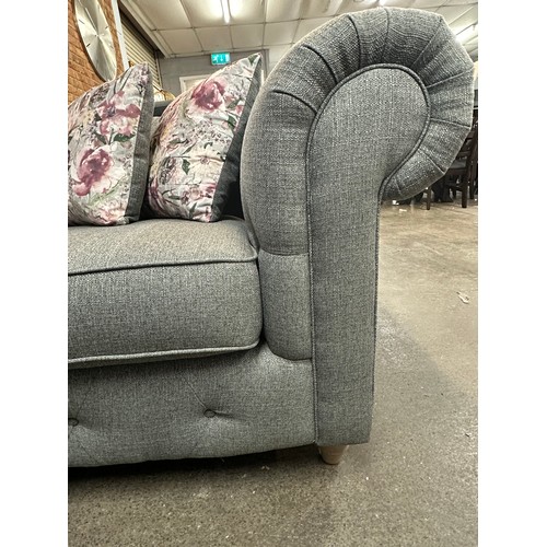 3168 - A dark grey upholstered textured weave two seater Chesterfield sofa with patterned scatter cushions