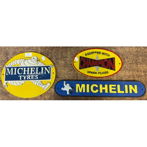 254 - Two Michelin painted advertising signs and a Champion spark plugs sign