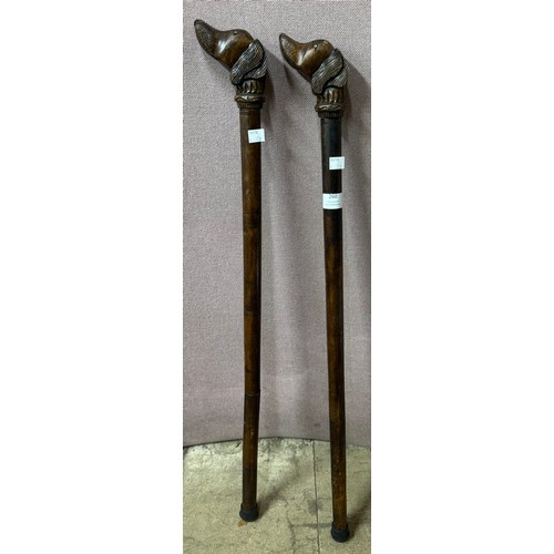 260 - A pair of oak walking sticks with handles in the form of dogs heads