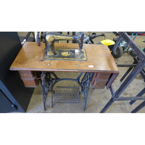 5185 - A vintage belt driven Singer sewing machine (11812352) mounted to a cast metal Singer sewing table