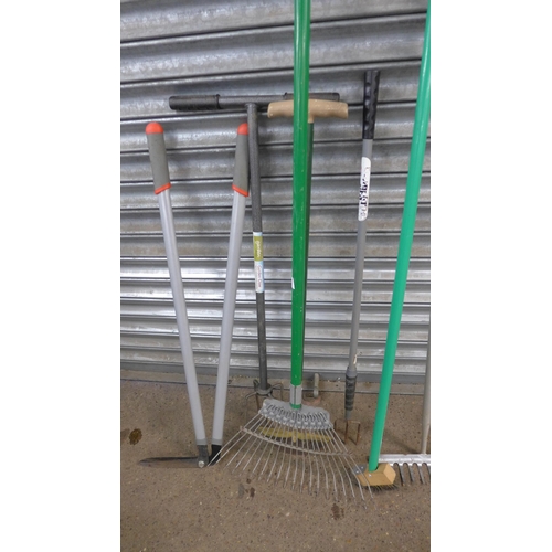 5194 - A quantity of garden tools including a pick axe, rake, lawn edging shears, patio and decking brush, ... 