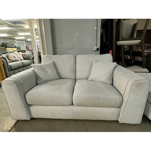 3211 - An ivory textured weave upholstered two seater sofa