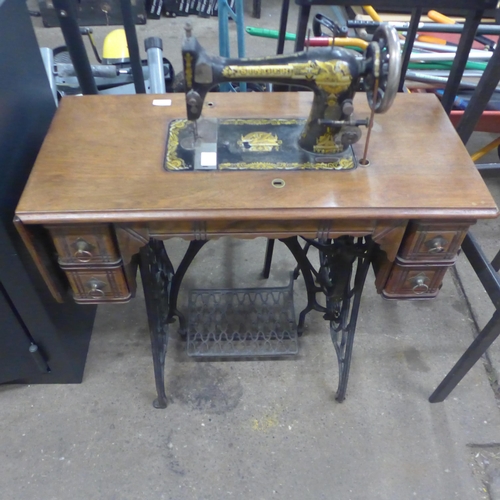 5185 - A vintage belt driven Singer sewing machine (11812352) mounted to a cast metal Singer sewing table