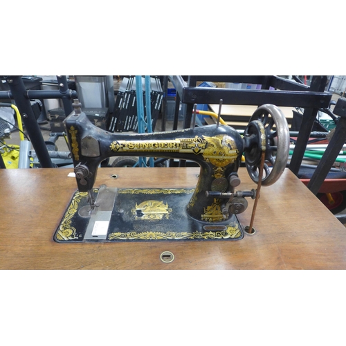 5185 - A vintage belt driven Singer sewing machine (11812352) mounted to a cast metal Singer sewing table