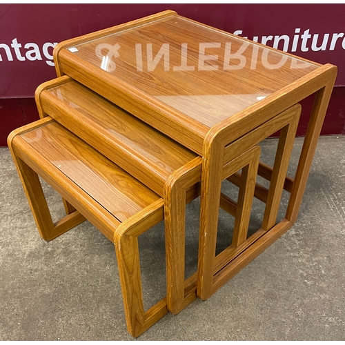 67 - A teak and glass topped nest of tables