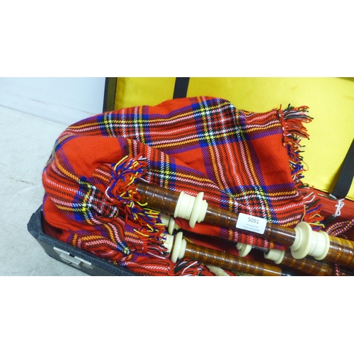 5091 - A set of bagpipes in a hard case with replacement reeds