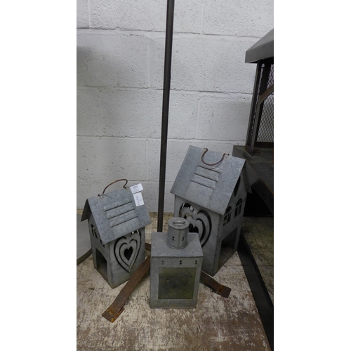 5225 - A metal outdoor candle stand and a set of 3 metal lanterns