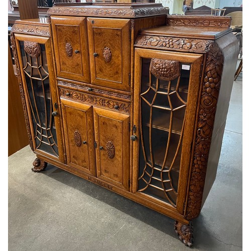 115 - An early 20th Century extensively carved oak and walnut cocktail cabinet