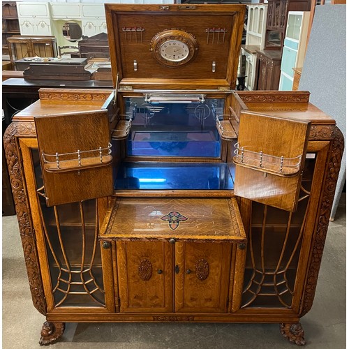 115 - An early 20th Century extensively carved oak and walnut cocktail cabinet