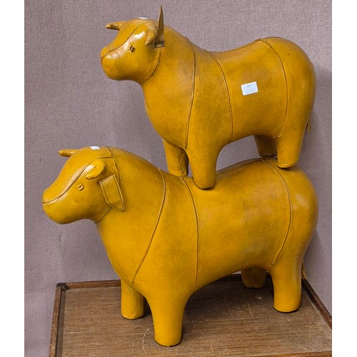 292 - A pair of Liberty & Co. style butterscotch leather footstools, a bull and a calf