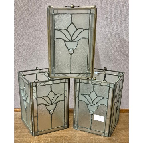 256 - A set of three brass and glass ceiling lanterns