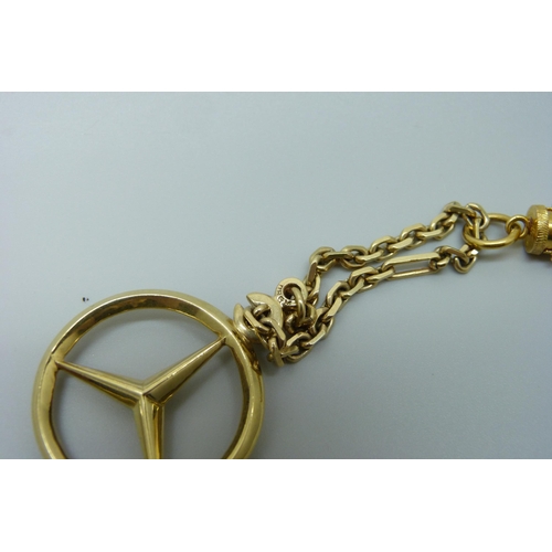 7018 - A yellow metal toothpick/ear scoop with Chinese marks on a 14ct gold chain with Mercedes Benz pendan... 