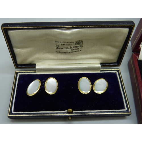 7048 - A pair of mother of pearl set cufflinks and two green stone set cufflinks/buttons