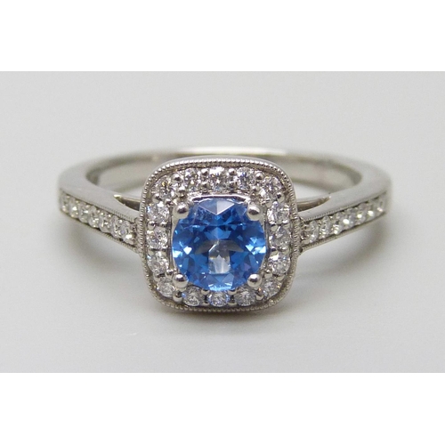 7056 - A platinum ring set with a Swarovski blue natural topaz surrounded with brilliant cut diamonds and d... 