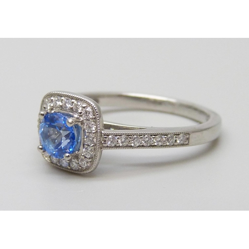 7056 - A platinum ring set with a Swarovski blue natural topaz surrounded with brilliant cut diamonds and d... 