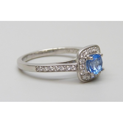 7056 - A platinum ring set with a Swarovski blue natural topaz surrounded with brilliant cut diamonds and d... 